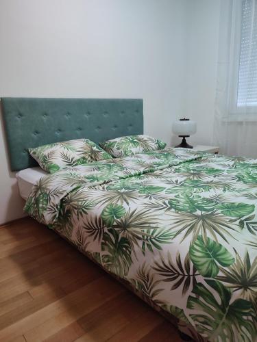 1 cama con edredón y almohadas verdes y blancos en Studio 33, en Banja Luka
