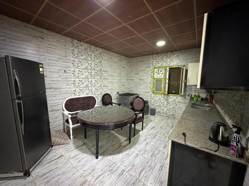 a kitchen with a table and chairs in a room at واحة بكار in Bawiti