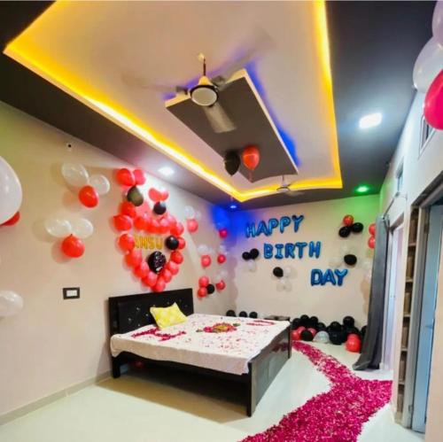 Habitación con fiesta de cumpleaños con globos y cama en Mg hotel, en Bīr