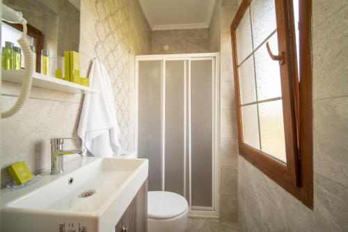 a bathroom with a sink and a toilet and a window at GRAPE DATÇA in Kızlanköy