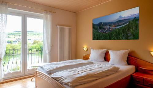 ein Schlafzimmer mit einem Bett und einem großen Fenster in der Unterkunft Weingut / Gästehaus Gerlach in Ürzig