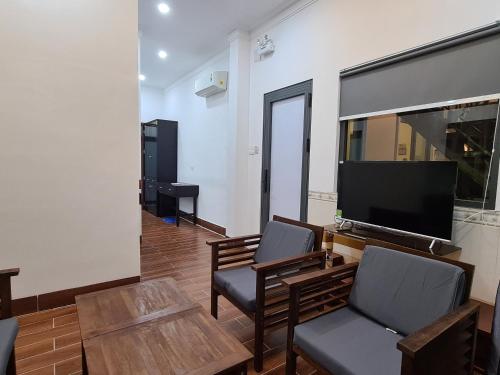 a living room with two chairs and a flat screen tv at RUBY HOTEL Vĩnh Long in Vĩnh Long