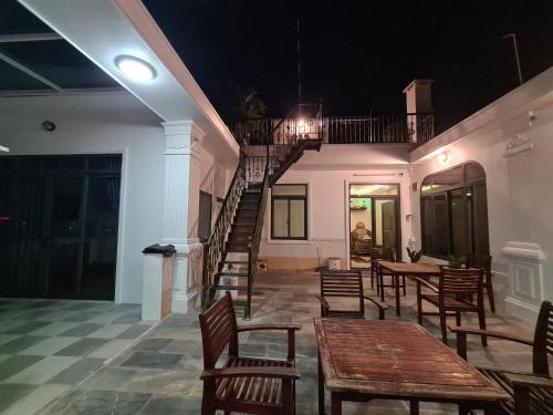 a restaurant with wooden tables and chairs and a staircase at RUBY HOTEL Vĩnh Long in Vĩnh Long