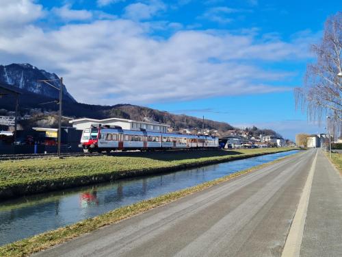 a train traveling down a road next to a river at Apartment Le 55Cici by Interhome in Bouveret