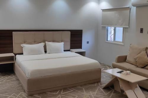a bedroom with a large bed and a couch at Maro Hotel in Abha