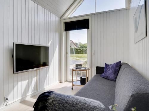 a living room with a couch and a flat screen tv at Holiday Home Solfrid - all inclusive - 150m from the sea by Interhome in Esbjerg