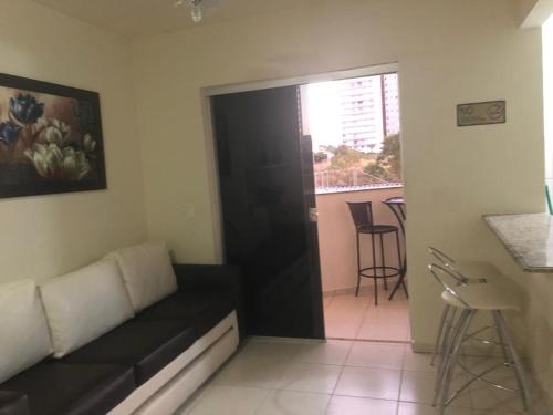 ein Wohnzimmer mit einem schwarzen Sofa und einem Tisch in der Unterkunft THERMAS DO BANDEIRANTE in Caldas Novas