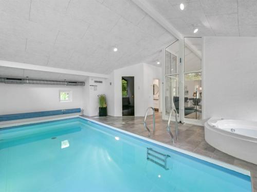 ein Badezimmer mit einem Pool, einer Badewanne und einem Waschbecken in der Unterkunft Holiday Home Liviana - all inclusive - from the sea by Interhome in Blåvand
