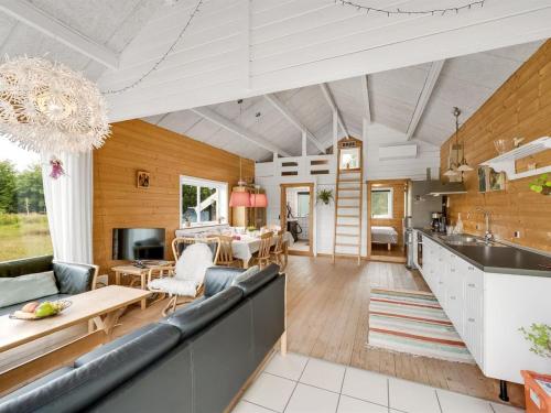 eine Küche und ein Wohnzimmer mit einem Sofa und einem Tisch in der Unterkunft Holiday Home Oddger - all inclusive - 250m to the inlet by Interhome in Skjern
