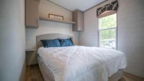 une chambre avec un lit blanc et une fenêtre dans l'établissement 2 Bedroom Waterfront Cottage Cedar Point Cres 4, à Campbellford