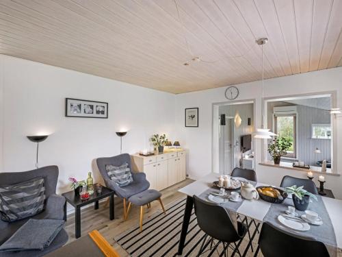ein Wohnzimmer mit einem Tisch und Stühlen in der Unterkunft Holiday Home Westi - all inclusive - 650m to the inlet by Interhome in Hemmet