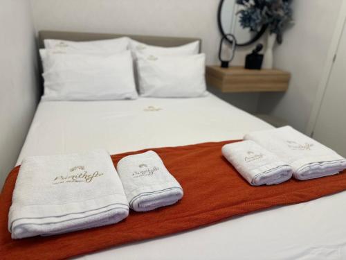 a bed with two folded towels on top of it at Psimithefto Luxury Apartments in Thessaloniki