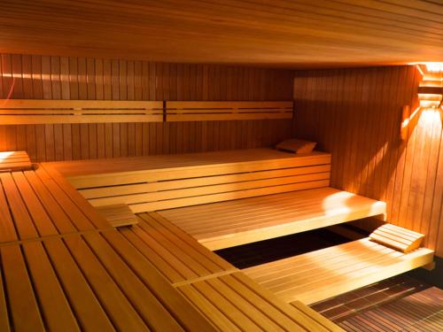 a sauna with two beds in a wooden room at Berghotel Habbel und die Welt kann warten in Cobbenrode