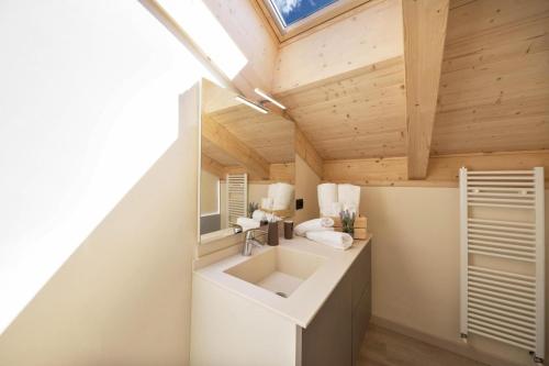 an attic bathroom with a sink and a mirror at CASA PARE' B&B in Tesero