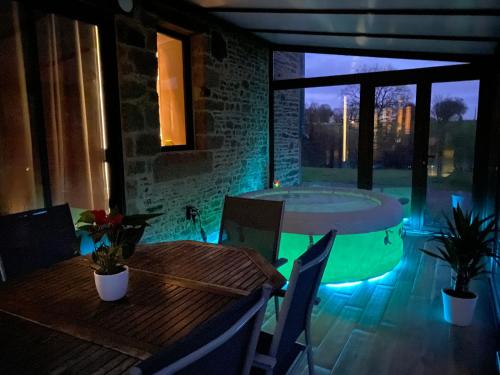 un bain à remous dans un patio avec une table et des chaises dans l'établissement La Venais, maison de campagne, à Isigny-le-Buat