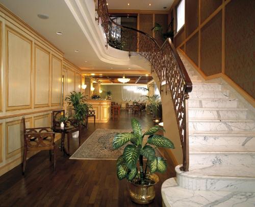 a lobby with a spiral staircase with a potted plant at Hotel De La Ville in Saint Vincent