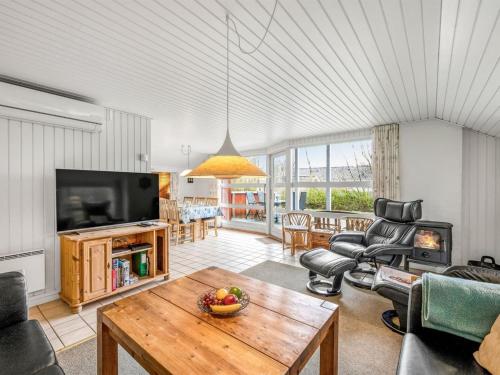 a living room with a table and a tv at Holiday Home Franzine - all inclusive - 500m to the inlet by Interhome in Hemmet