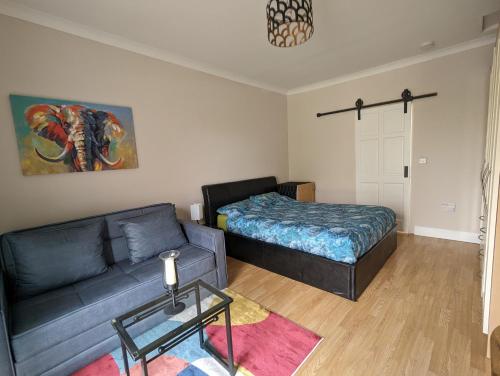 a living room with a couch and a bed at Cozy Getaway in Bunratty in Droíchead an Chláir
