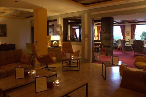 a living room with couches and tables and chairs at Berghotel Habbel und die Welt kann warten in Cobbenrode