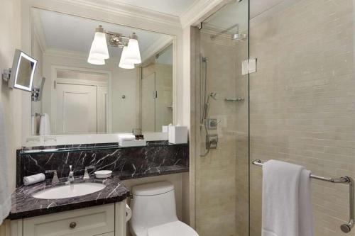 a bathroom with a shower and a toilet and a sink at Fairmont Royal York Hotel in Toronto