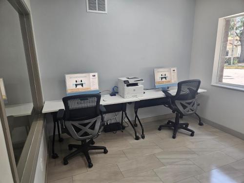 a office with two computers on a desk with two chairs at Holiday Inn Express & Suites Clermont SE - West Orlando by IHG in Orlando