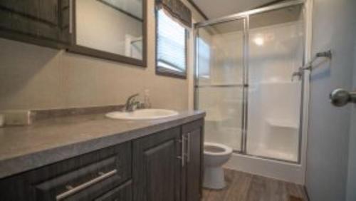 ein Bad mit einem Waschbecken, einer Dusche und einem WC in der Unterkunft 3 Bedroom Cottage Forest Grove Lane 75 in Cherry Valley