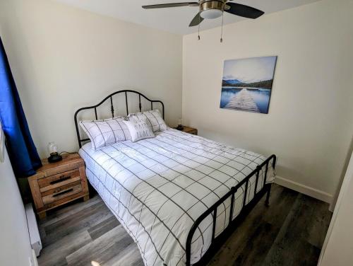 1 dormitorio con 1 cama y ventilador de techo en Newly Renovated 2 Bedroom Beach Front Condo 2A, en Lanark