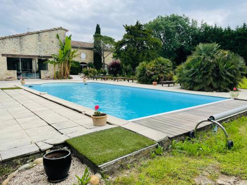 - une grande piscine dans une cour avec une maison dans l'établissement Le mas du mûrier - Portes de Provence - Mas de 1890 rénové avec climatisation, à Loriol-sur-Drôme