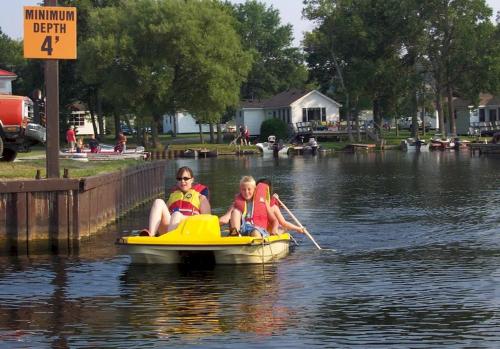 two people are riding on a boat in the water at 2 Bedroom Harbor Front Condo 6L in Roseneath