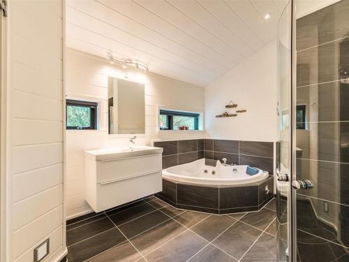 een badkamer met een bad, een wastafel en een douche bij Holiday Home Elisenda - all inclusive - 625m from the sea by Interhome in Skagen
