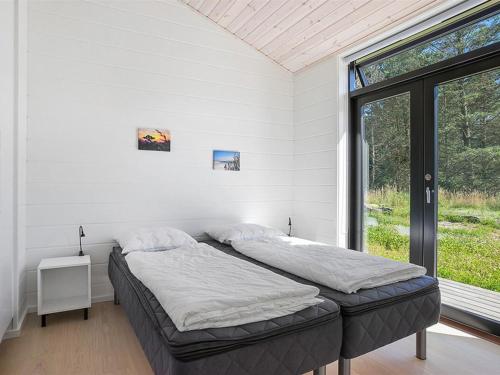 two beds in a white room with a window at Holiday Home Elisenda - all inclusive - 625m from the sea by Interhome in Skagen