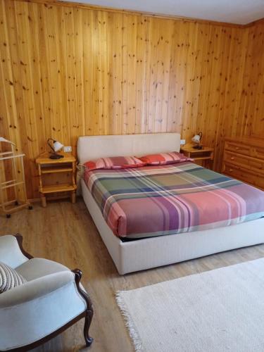 una camera con letto e pareti in legno di Bormio Flat a Bormio