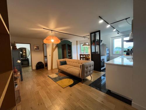 a living room with a couch and a kitchen at Les Rives Rémoises in Reims