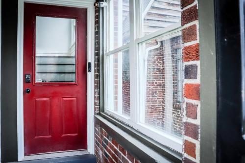 a red door on a brick building with a window at Downtown Retreat - 2BR Oasis with Parking in Columbus