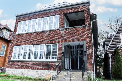 a red brick house with a door and stairs at Downtown Retreat - 2BR Oasis with Parking in Columbus