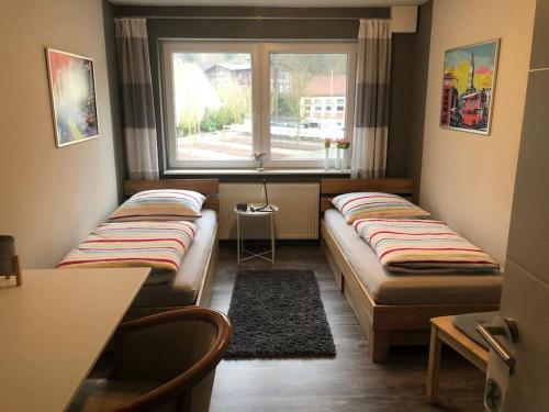 two beds in a room with a window at Fewo Pyramideneiche Detmold/Berlebeck, naturnah in Detmold