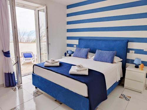 a blue and white bedroom with a bed and a balcony at My home Capri in Capri