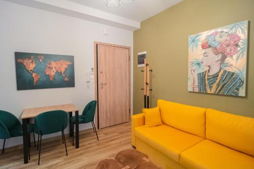 a living room with a yellow couch and a table at Ethra Suite 2 in Volos