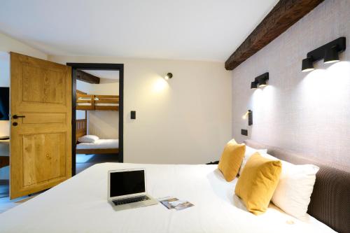a bedroom with a bed with a laptop on it at Les Tanneurs in Namur