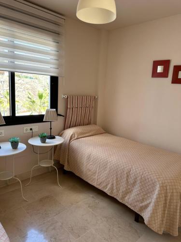 a bedroom with a bed and two side tables at Apartamento frente al mar con parking privado in Torrox