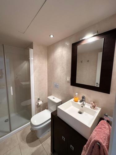 a bathroom with a sink and a toilet and a mirror at Apartamento frente al mar con parking privado in Torrox