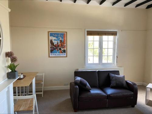 a living room with a couch and a table at Above The Pub in Alvechurch