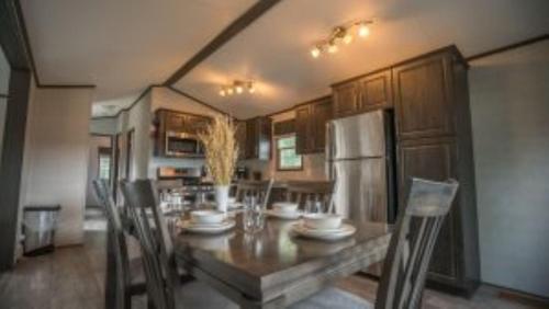 une cuisine avec une table avec des chaises et un réfrigérateur dans l'établissement 2 Bedroom Cottage Tamarack Trail 1, à Campbellford