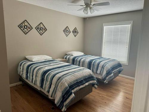 a bedroom with two beds and a ceiling fan at Three Schooners Landing Condo 2 in Sodus Point