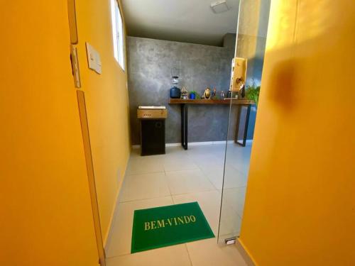 a hallway with a green sign on the floor in a kitchen at Cantinho do Tigela in Bananeiras