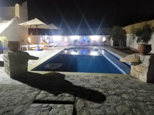 una piscina por la noche con la sombra de un pájaro en Essaouira à louer, appartement avec piscine privée, en Bou Mkila