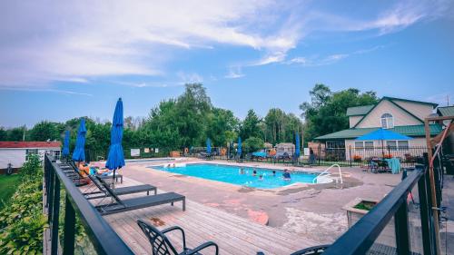 una gran piscina con sillas y sombrillas en 3 Bedroom Cottage Tamarack Trail 5, en Campbellford