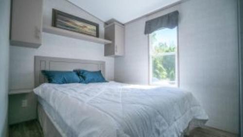 Habitación blanca con cama y ventana en 3 Bedroom Cottage Tamarack Trail 5, en Campbellford