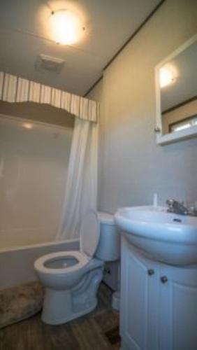 a bathroom with a white toilet and a sink at 3 Bedroom Cottage Dragon Fly Drive 7 in Cherry Valley