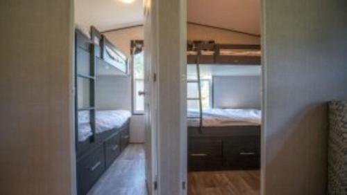 um quarto com 2 beliches e uma porta para um quarto em 3 Bedroom Cottage Dragon Fly Drive 7 em Cherry Valley